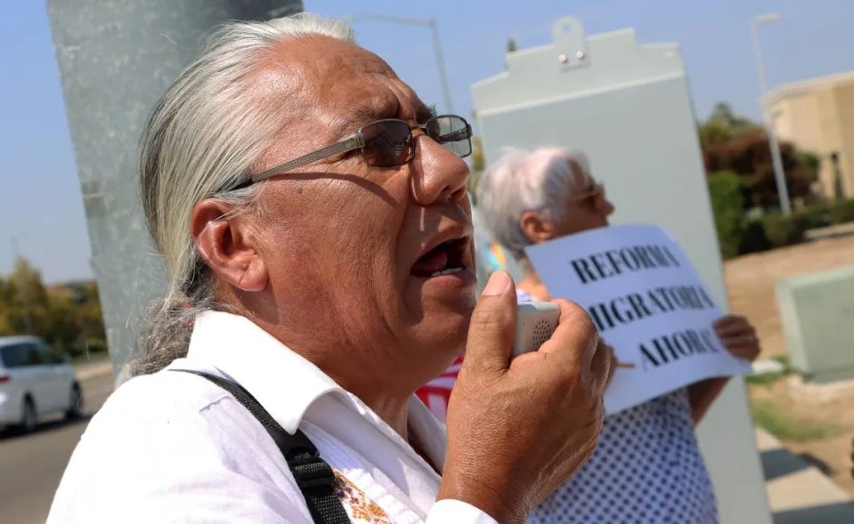 Male protestor speaking into a megaphone’s microphone protesting in favor of immigration reform.